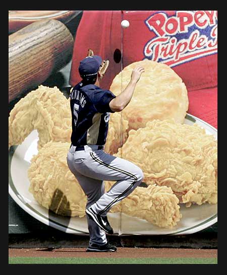 Milwaukee Brewers outfielder Geoff Jenkins battles oversized poultry pieces to try to snag a ball.